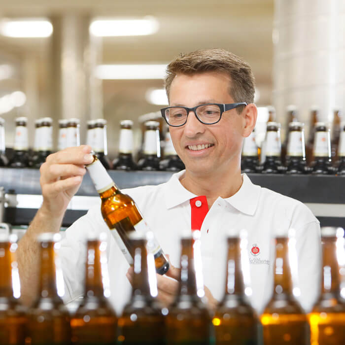Ein Mitarbeiter der König-Brauerei kontrolliert die Flaschen in der Abfüllanlage